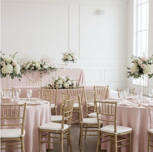 Blush celebration room with gold chiavari chairs, sequin accents, and white floral centerpieces