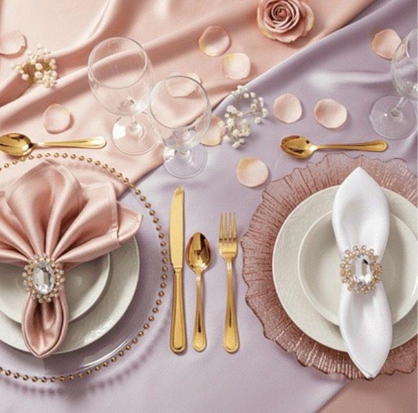 Blush and lavender place settings with gold flatware, jeweled napkin rings, and rose petals