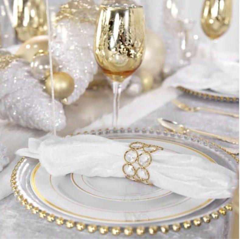 Winter white place setting with gold-beaded charger, crystal napkin ring, and gold mercury-glass stemware